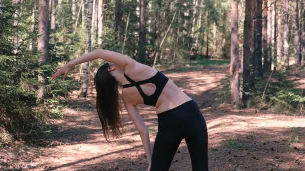 Wanita dalam pakaian olahraga melakukan yoga di taman. Pandangan ke belakang. Gerakan lambat . — Stok Video