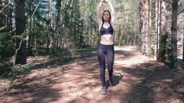 Vrouw in sportkleding is omhoog in het Park en warm voordat Jogging. — Stockvideo