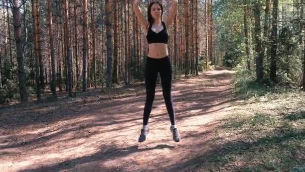 Wanita melakukan latihan olahraga di hutan dekat danau. Gerakan lambat . — Stok Video