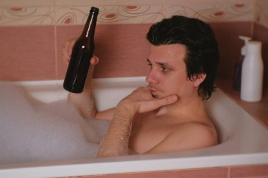 Adam bir banyo alır ve bira içiyor. Depresyon ve yaşam sorunları.