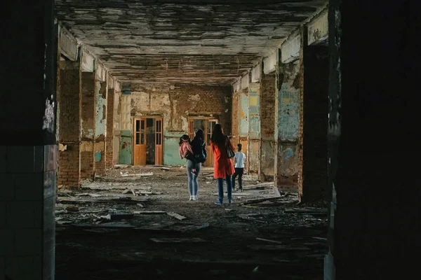 Women with kids inspects destroyed building after the disaster earthquake, flood, fire.