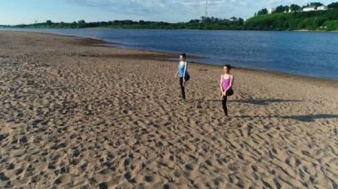 İki şehrin nehir kenarında kumsalda yoga yaparken kadın. Güzel manzara. Vrikshasana poz.
