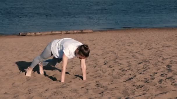 Frau beim Sport am Ufer des Flusses in der Stadt. Plankenübung. — Stockvideo