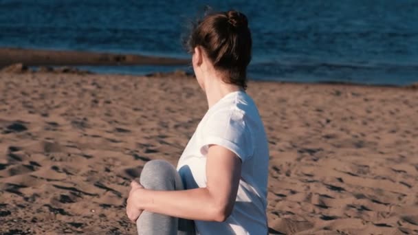 Mujer estirando yoga en la playa junto al río en la ciudad. Hermosa vista . — Vídeos de Stock