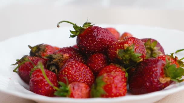 Saftiga aptitretande välsmakande jordgubbar på en vit platta. Närbild. — Stockvideo