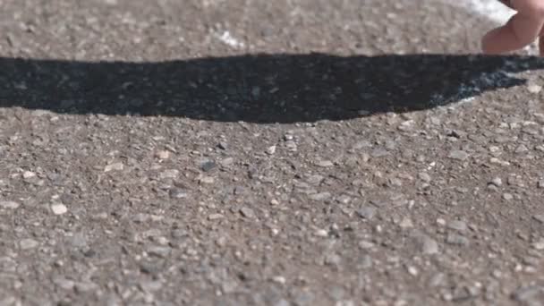 La donna disegna una linea sull'asfalto con gesso bianco. Primo piano mano . — Video Stock