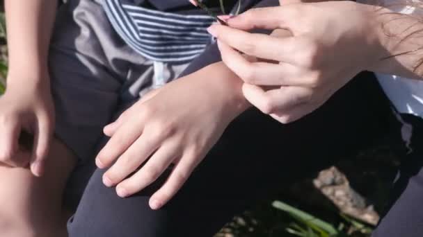 Mom puts on her sons hand weaved braid from leaves. — Stock Video