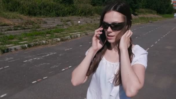Mujer joven hablando de teléfono móvil caminando en el estadio . — Vídeos de Stock