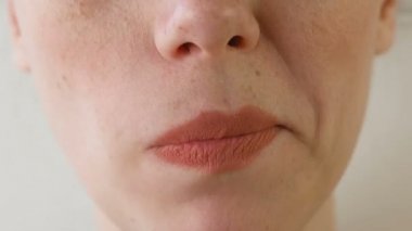 Kadın çilek yiyor. Ağız yakın çekim. Önden görünüm.