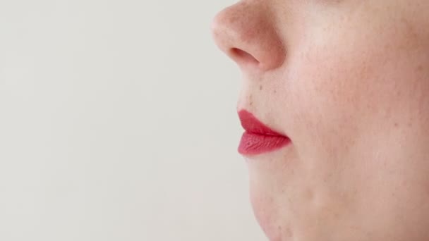 Mulher com lábios vermelhos come morangos. Fechar a boca. Vista lateral . — Vídeo de Stock