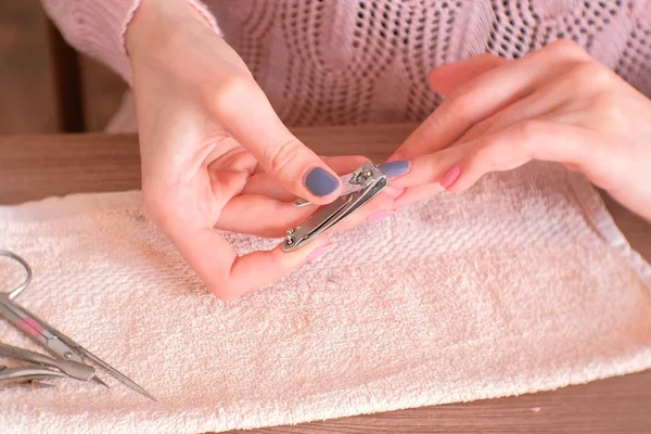 Kvinna skar sina naglar med clippers. Närbild händer. — Stockfoto