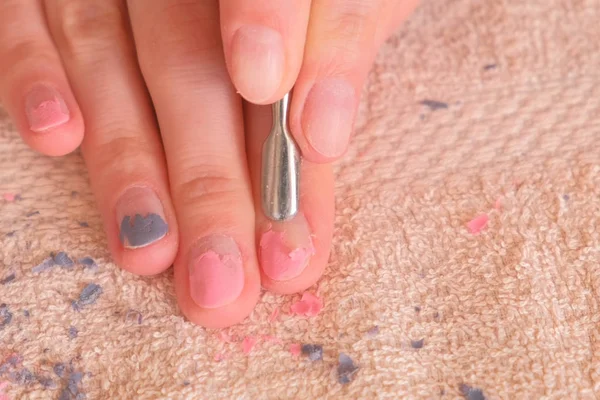 Woman removes shellac from nail with pusher. Close-up hand. — Stock Photo, Image