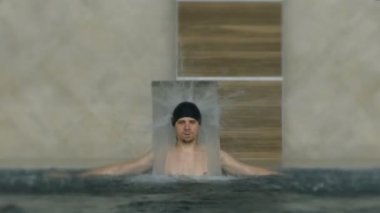 Havuzu spa gün zevk rahatlatıcı tatil beldesinde bir genç adam. Hidro masaj boyun ağrısı için. Altında su jet, boyun ve omurga masajı rahatlatıcı.