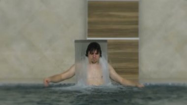 Havuzu spa gün zevk rahatlatıcı tatil beldesinde bir genç adam. Hidro masaj boyun ağrısı için. Altında su jet, boyun ve omurga masajı rahatlatıcı.