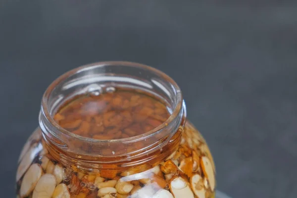 Rotující otevřené nádobky s ořechy v medu. Pohled shora detail. — Stock fotografie