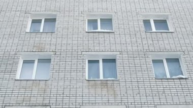 Altı beyaz windows bir tuğla ev. Binanın dış görünümü. Kamera alttan yukarı taşı