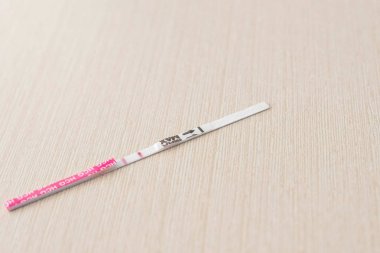 Positive pregnancy test result with two strips on the table. Two stripes on a test. clipart