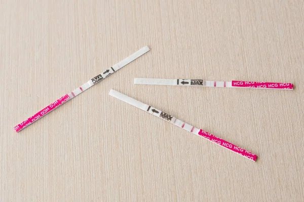 Три положительных результата теста на беременность с двумя полосками на столе — стоковое фото