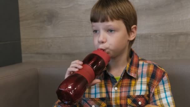 Niño bebe agua de una botella de deportes en la cafetería . — Vídeos de Stock