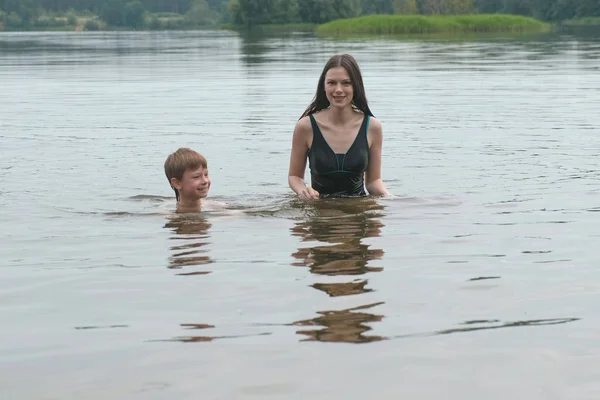Μητέρα και γιος κολυμπούν μαζί στη λίμνη στη θερινή ημέρα. — Φωτογραφία Αρχείου