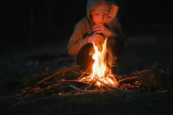 Семилетний мальчик зажигает костер в лесу . — стоковое фото