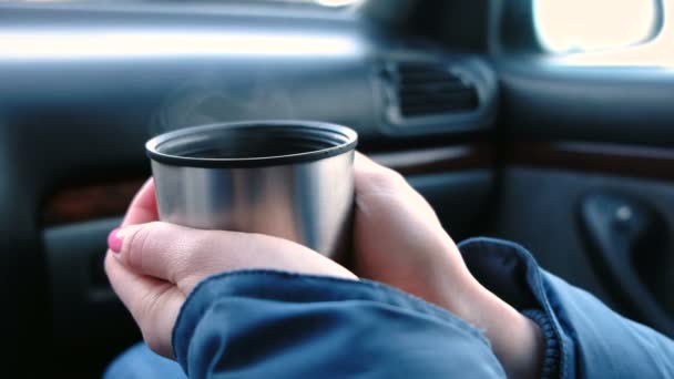 Close-up beeld van dames handen houden een kop hete thee van thermos zittend in de auto in de winter. — Stockvideo