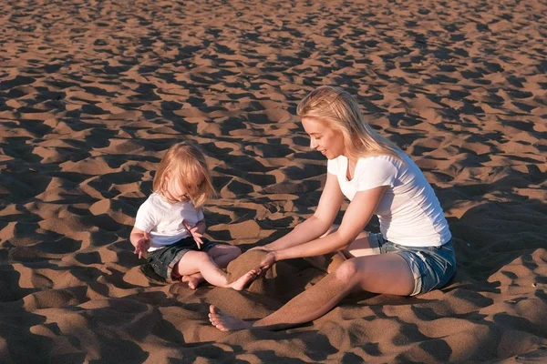 Piękna Blondynka Mama i córka Zagraj z piasku siedzieli na plaży. — Zdjęcie stockowe