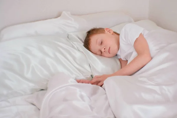 Menino de sete anos dormindo em sua cama — Fotografia de Stock