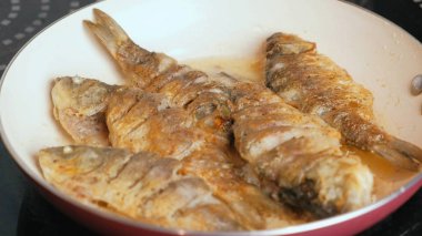 Küçük carps balık yağı bir tavada kızarmış.