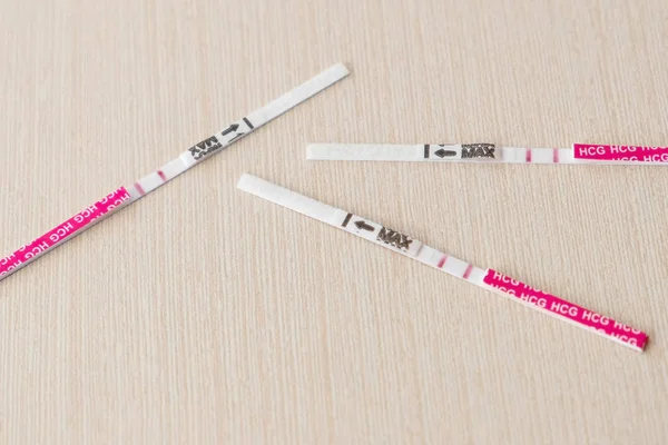 Три положительных результата теста на беременность с двумя полосками на столе — стоковое фото