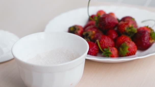 Sappige smakelijk smakelijke aardbei op een witte plaat met suikerpot. — Stockvideo