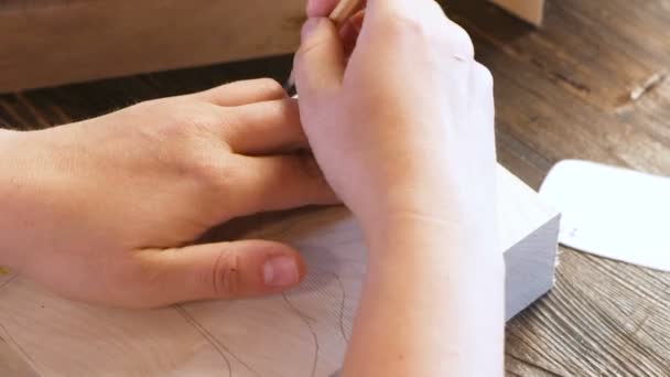Жінка перефарбовує паперовий трафарет у дерев'яний брусок. Руки крупним планом . — стокове відео