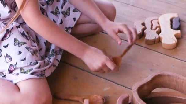 Meisje spelen met houten lepels. — Stockvideo