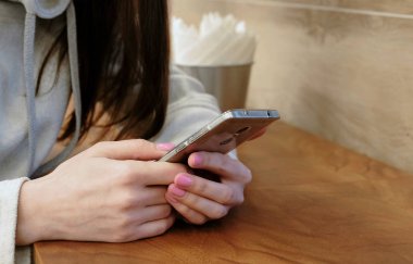 Yakın çekim kadının telefonunu kafede oturan çalışma parlak gömlekli eller.