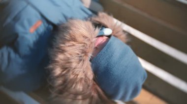 Kadın parkta bir bankta bir şapka yüzünde yalan süre gülüyor. Dudaklar yakın çekim.