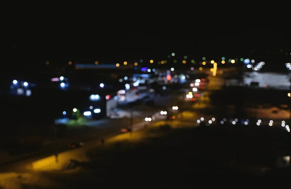 Vista borrosa de la ciudad y la carretera desde una altura. Tráfico de autos borrosos en la ciudad. Noche. . — Foto de Stock