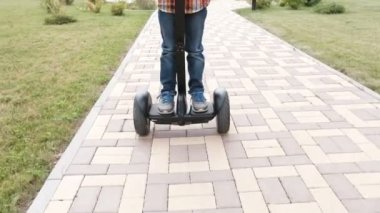 Tanınmayan çocuk evinizin yakınında gyro scooter üzerinde inişli çıkışlı olduğunu. Bacaklar yakın çekim.