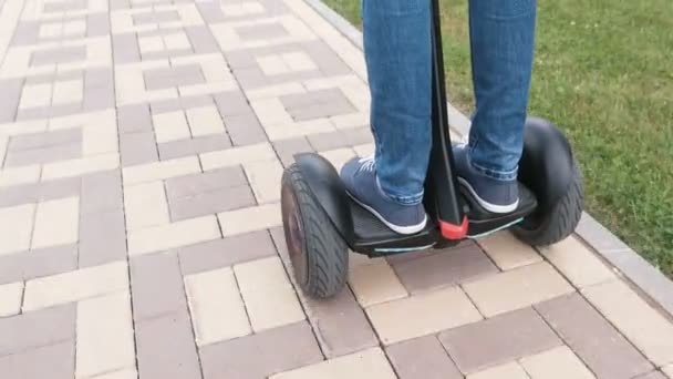 ジャイロ スクーター舗装道路の上を転がるスニーカーで人の足. — ストック動画
