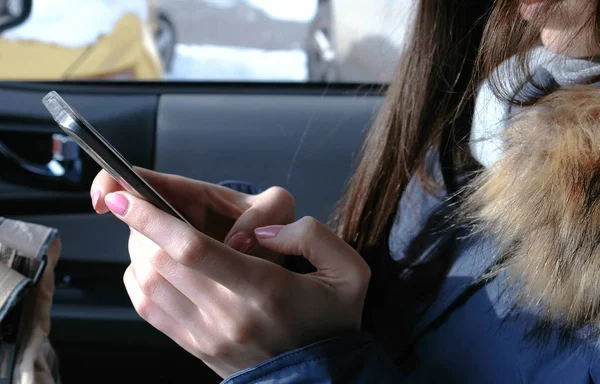 Mujer en un coche con teléfono móvil. Primeros planos de las mujeres manos charlando en el teléfono . — Foto de Stock