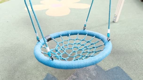 Blue empty webbed swing in playground. — Stock Video