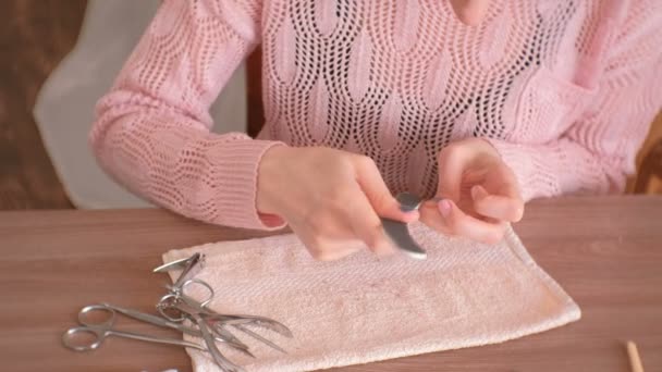 Vrouw poetsmiddelen haar nagels met nagelvijl vóór verwijderen schellak. Close-up van de handen. — Stockvideo