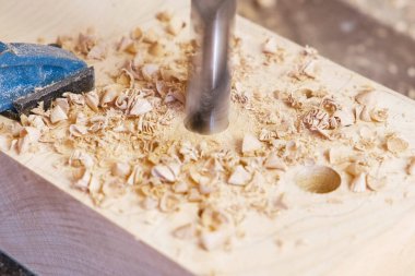 İşçi ahşap şablonları delikler girer. Ahşap oyuncak imalatı. Yakın çekim yakışıklı.