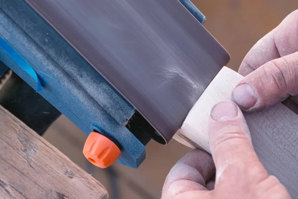 Tischler poliert ein Holzteil auf einer Schleifmaschine. Hände aus nächster Nähe. — Stockfoto