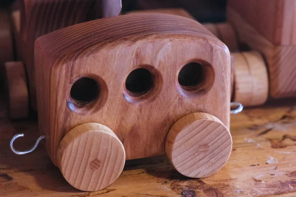 Wooden toy car trailer on the table in the workshop. — Stock Photo, Image