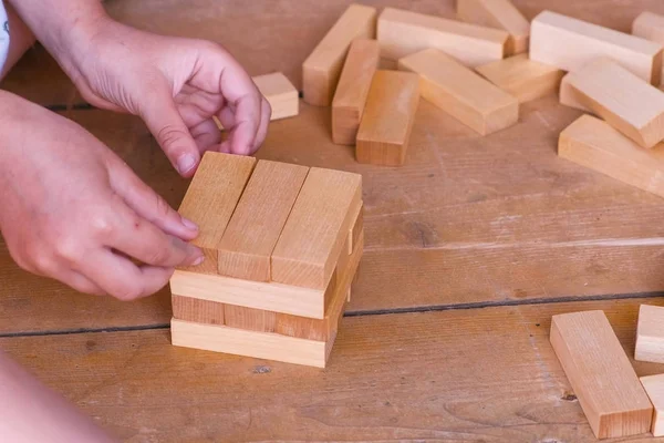 Küçük kız ahşap bloklar bir kuleden oluşturur. Yakın çekim yakışıklı.