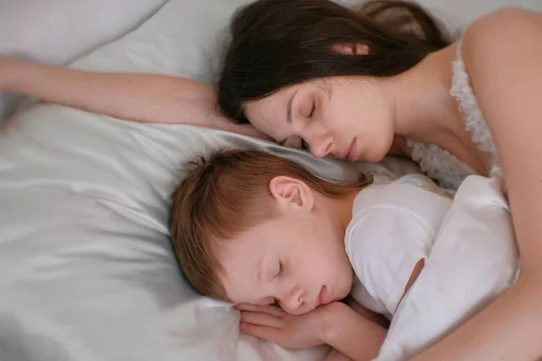 Mãe e filho dormindo juntos. Mãe abraçando seu filho . — Fotografia de Stock