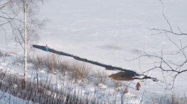İnsanlar kış parkta bir donmuş nehir kıyısında yürüyüş