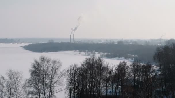 Winterliche Stadtlandschaft mit rauchenden Fabrikschloten. — Stockvideo