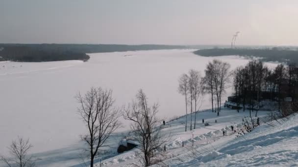 Winterliche Stadtlandschaft mit rauchenden Fabrikschloten und Winterpark mit spazierenden Menschen. — Stockvideo