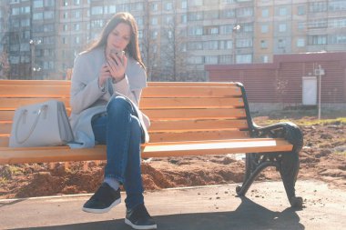 Güzel esmer telefonunu bir çok katlı binanın avlusunda bir mesaj yazarak portresi.